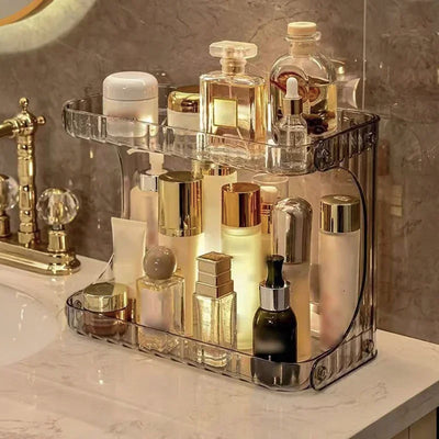 Clear acrylic bathroom countertop organizer holding various perfume and skincare bottles in a luxurious vanity setup