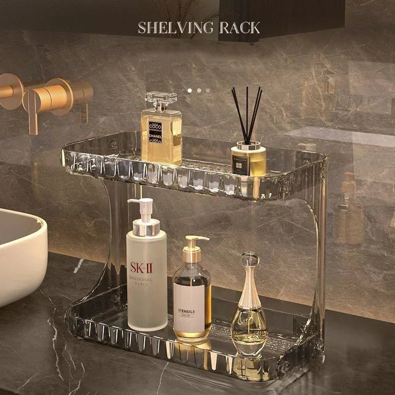 Acrylic bathroom countertop shelving rack used to neatly organize skincare and fragrance bottles in a modern vanity