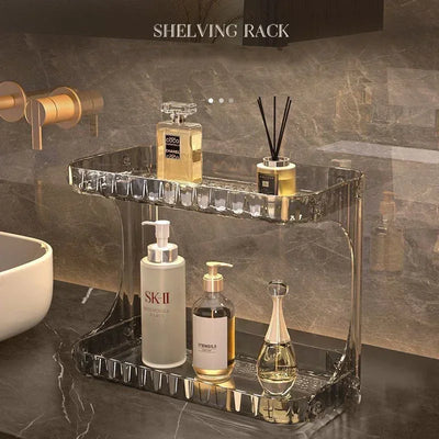 Acrylic bathroom countertop shelving rack used to neatly organize skincare and fragrance bottles in a modern vanity