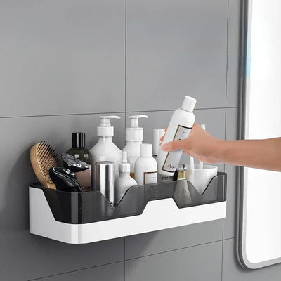 Hand reaching for a bottle of shampoo on a wall-mounted bathroom shelf.