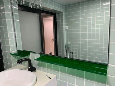 Green floating corner shelf organizer rack mounted in bathroom under large vanity mirror