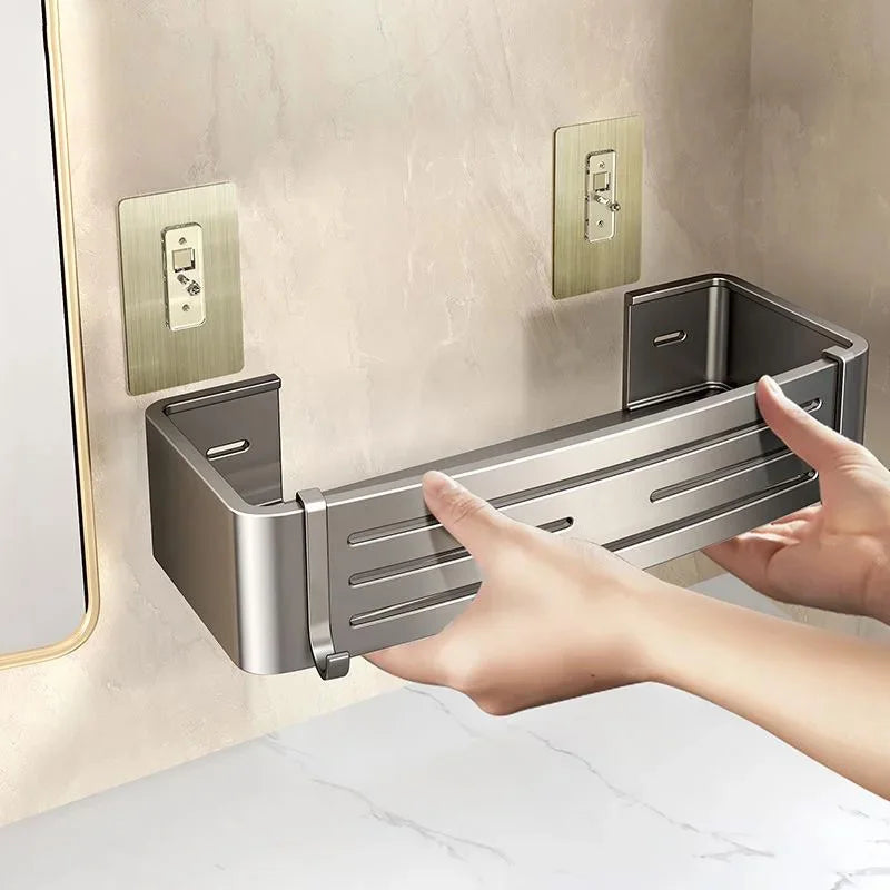 Metal wall-mounted shelf being adjusted by a hand in a bathroom setting.